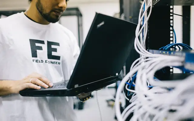 Administrateur réseau devant une baie informatique